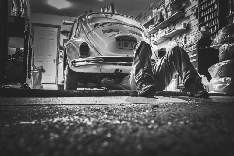 Mecánico reparando Volkswagen Beetle clásico